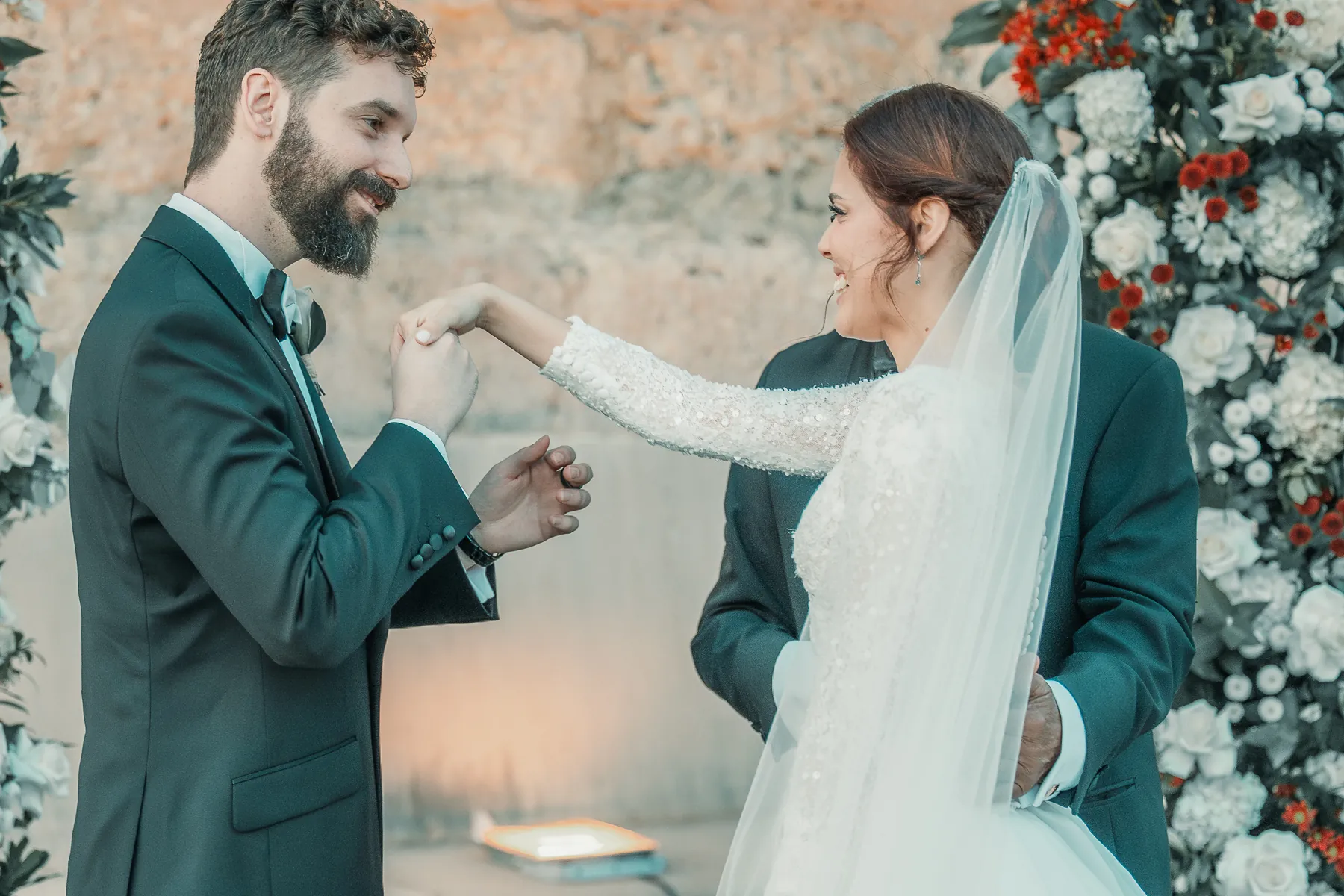 El novio sonríe al recibir a la novia en el altar